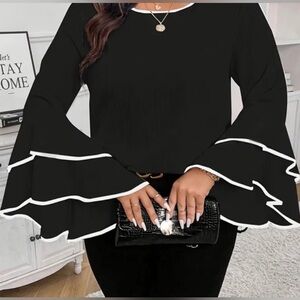 Elegant black blouse with white trimmed bell sleeves.
